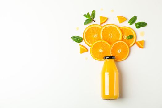 Flat lay composition with orange juice in bottle, orange pieces and mint on white background, space for text. Citrus drink and fruits