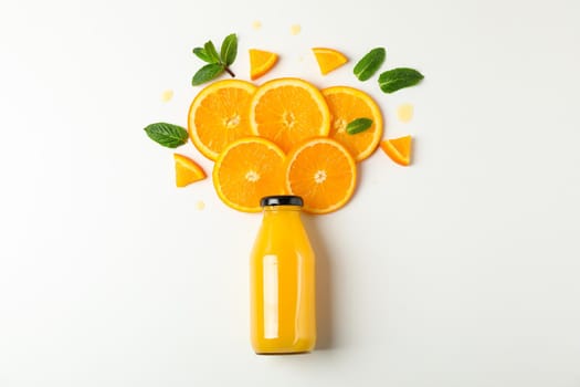 Flat lay composition with orange juice in bottle, orange pieces and mint on white background, space for text. Citrus drink and fruits