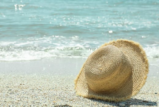 Straw hat on seaside, space for text. Summer vacation background