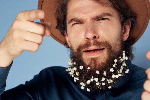 Bearded man in shirt hat flowers elegant style. High quality photo