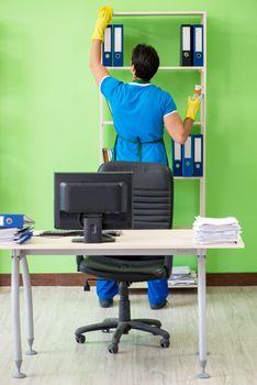 Male handsome professional cleaner working in the office
