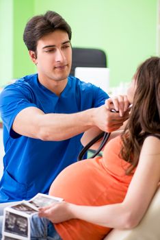 Pregnant woman visiting male gynecologyst at the clinic