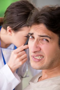 Female doctor checking patient's ear during medical examination 