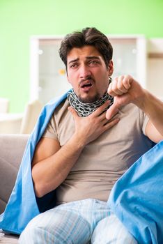 Sick young man suffering from flu at home