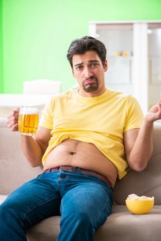 Fat obese man holding beer in dieting concept