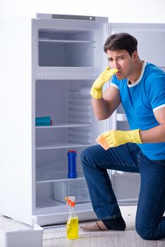 Man cleaning fridge in hygiene concept