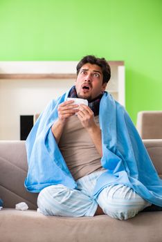Sick young man suffering from flu at home