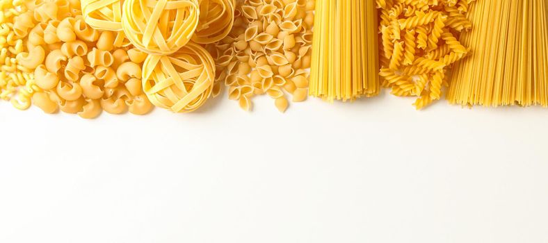 Different pasta on white background, space for text. Dry uncooked whole pasta