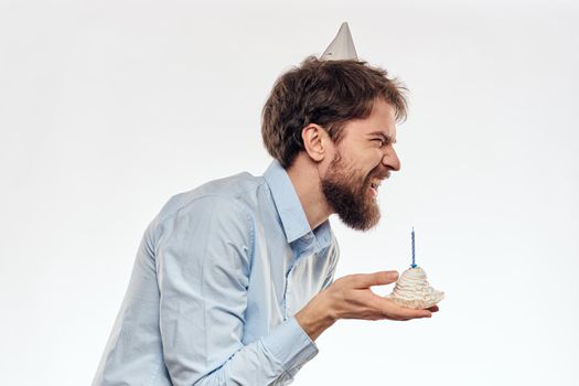 a man with a beard holds a cake in his hand on a light background birthday. High quality photo