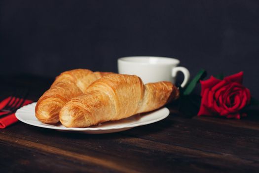 crispy croissants on a plate wooden table coffee mug. High quality photo