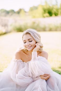 A close-up portrait of the bride with her eyes closed and her hand in her face. Wedding in Florence, Italy, in an old villa-winery.