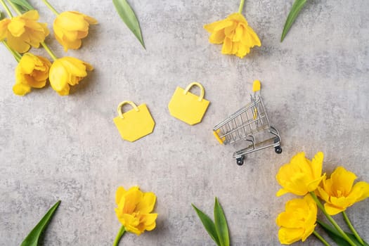 Concept of Mother's day holiday gift shopping greeting design with yellow tulip flower bouquet on gray background