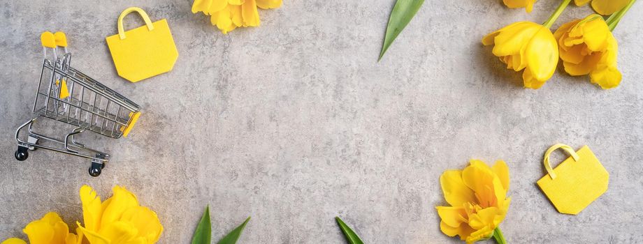 Concept of Mother's day holiday gift shopping greeting design with yellow tulip flower bouquet on gray background