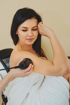 Close-up of massage with special ultrasonic device on female hand. Сosmetic treatments.