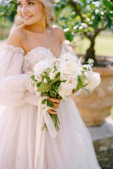 Wedding in Florence, Italy, in an old villa-winery. Bride with a bouquet in the garden, near the lemon tree.
