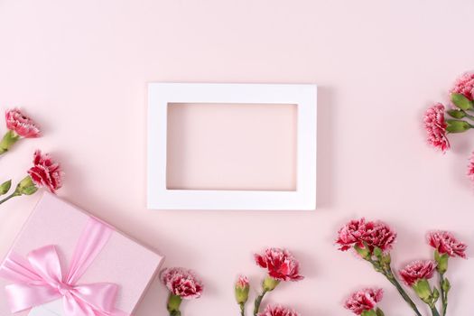 Concept of Mother's day holiday greeting background design  with carnations bouquet on pink background