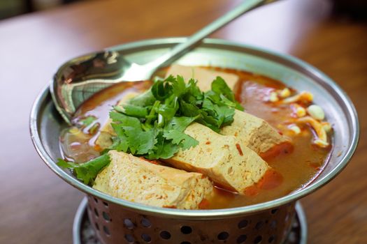 Eating stinky tofu hot pot with spicy soup using spoon, traditional street food in Taiwan.