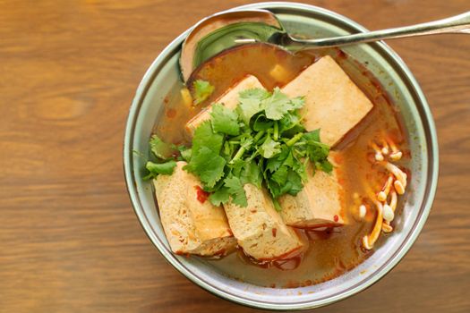 Eating stinky tofu hot pot with spicy soup using spoon, traditional street food in Taiwan.