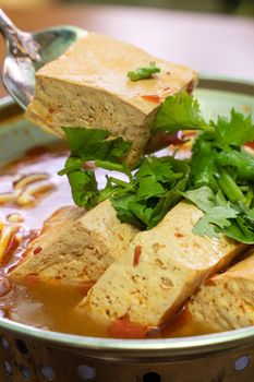 Eating stinky tofu hot pot with spicy soup using spoon, traditional street food in Taiwan.