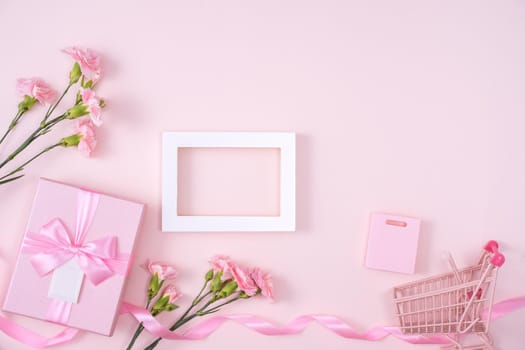 Concept of Mother's day holiday greeting design with carnation bouquet and gift on pink background