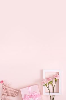 Concept of Mother's day holiday greeting design with carnation bouquet and gift on pink background