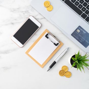 Top view of financial plan concept with credit card, laptop, note on white office table background.