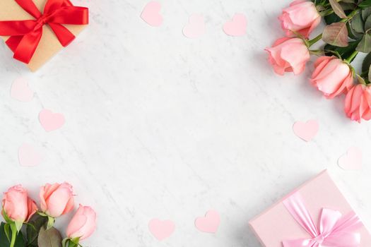 Giftbox and pink rose flower on marble white table background for Mother's Day holiday greeting design concept.
