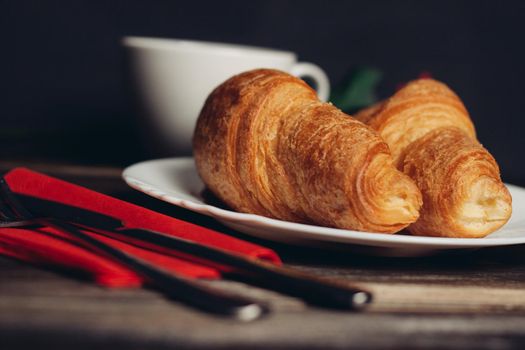 croissants on a white plate red coffee mug. High quality photo