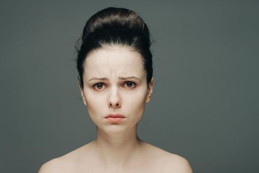 woman with bare shoulders clear skin collected hair emotions. High quality photo