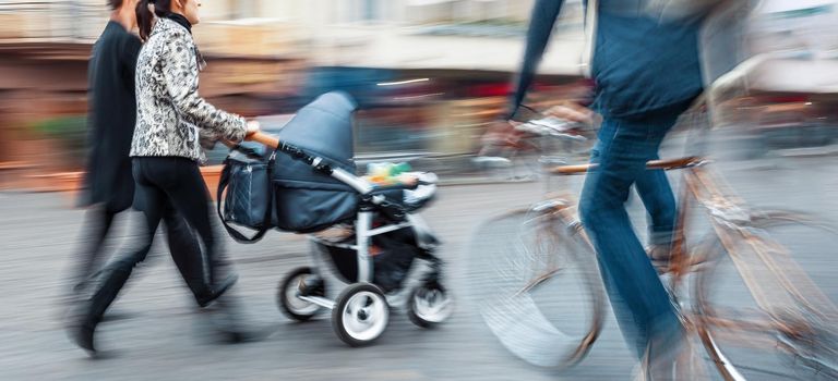 Dangerous situation on the road. Cyclist a second before a collision with a pram.  Intentional motion blur