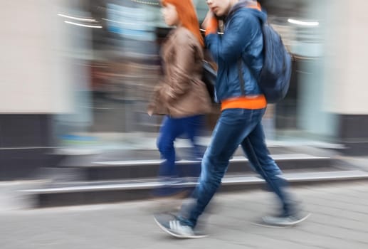 A group of young people going along the street. Intentional motion blur