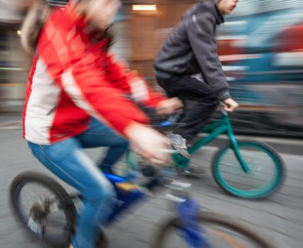 Two young boys on bicycles in the city. Intentional motion blur