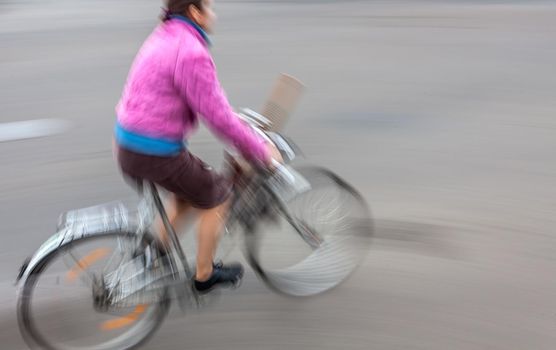 Cyclist in traffic on the city roadway. Intentional motion blur