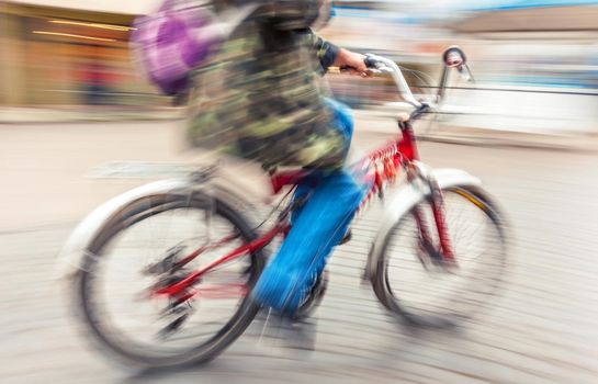 cyclist in traffic on the city roadway. Intentional motion blur