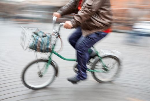 Abstract image of a large man on a little bike. Intentional motion blur