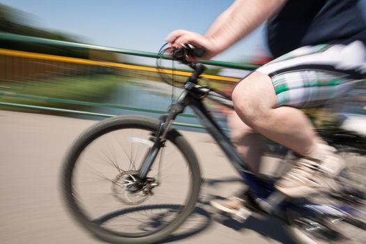 Fat man rides a bicycle on city streets. Intentional motion blur