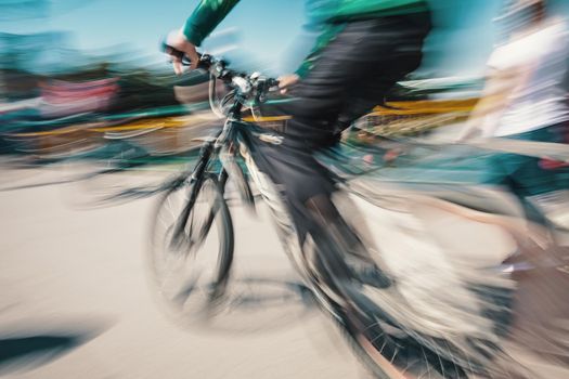 Cyclist on the city roadway in motion blur. Vintage filter with intentional color shift