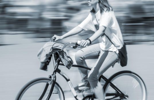 Cyclist in traffic on the city roadway. Intentional motion blur