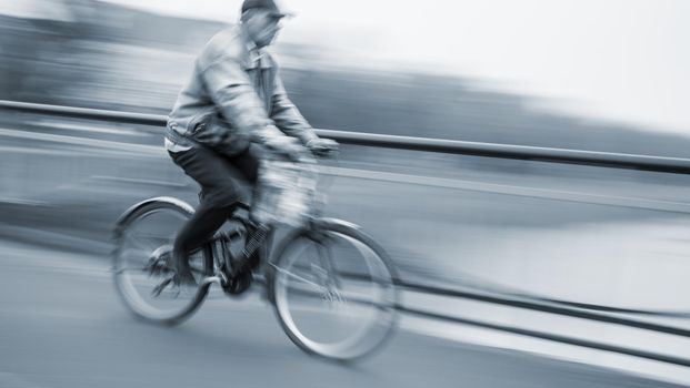 Abstract image of cyclist on the city roadway. Intentional motion blur