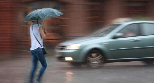People walking down the street in rainy day. Intentional motion blur