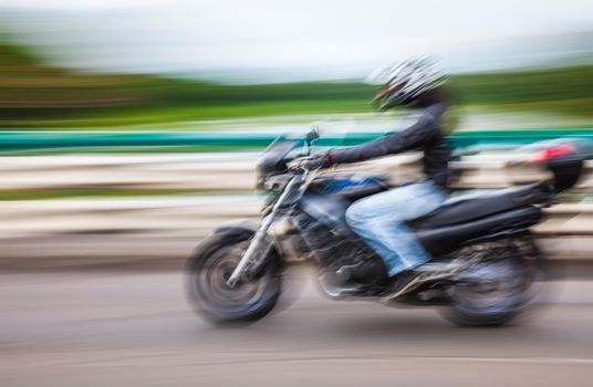 Abstract motion blur image of active people on motorcycle in the city roadway