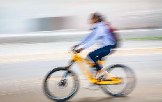 Abstract motion blur image of active people on bicycle in the city roadway