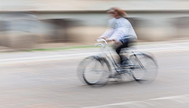 Abstract motion blur image of active people on bicycle in the city roadway