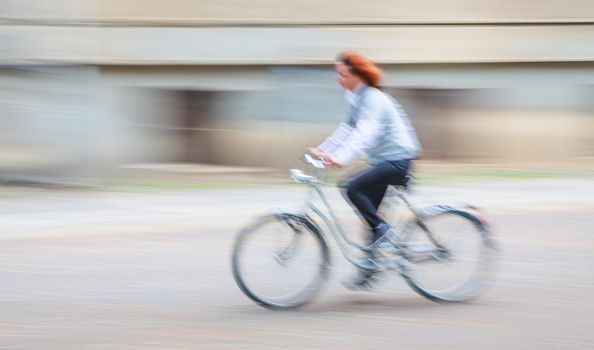 Abstract motion blur image of active people on bicycle in the city roadway