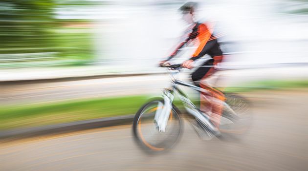 Abstract motion blur image of active people on bicycle in the city roadway