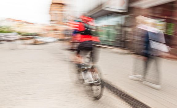 Abstract motion blur image of active people on bicycle in the city roadway