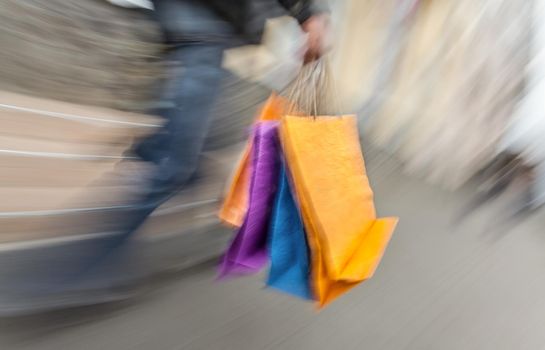 Holiday sales. Man with many shopping bags in his hand. Intentional motion blur