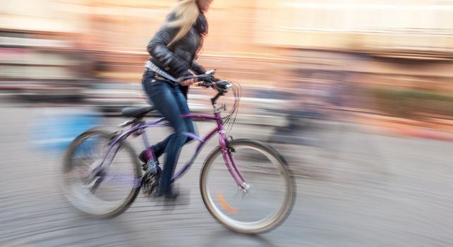 Cyclist in traffic on the city roadway. Intentional motion blur