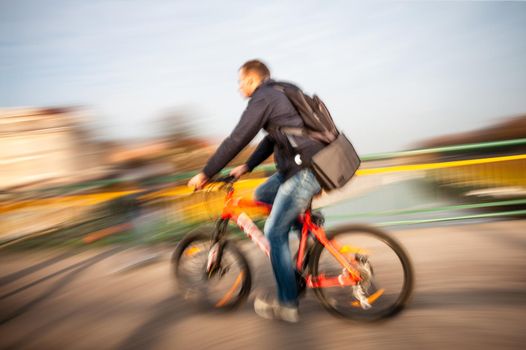 Cyclist on the city roadway in motion blur. Vintage filter with intentional color shift