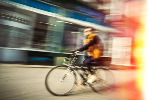 Cyclist on the city roadway in motion blur. Vintage filter with intentional color shift